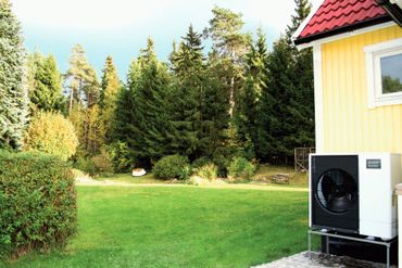 Ilma-vesilämpöpumpun ulkoyksikkö talon seinässä